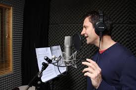 Voice actor recording audition demo in home studio.